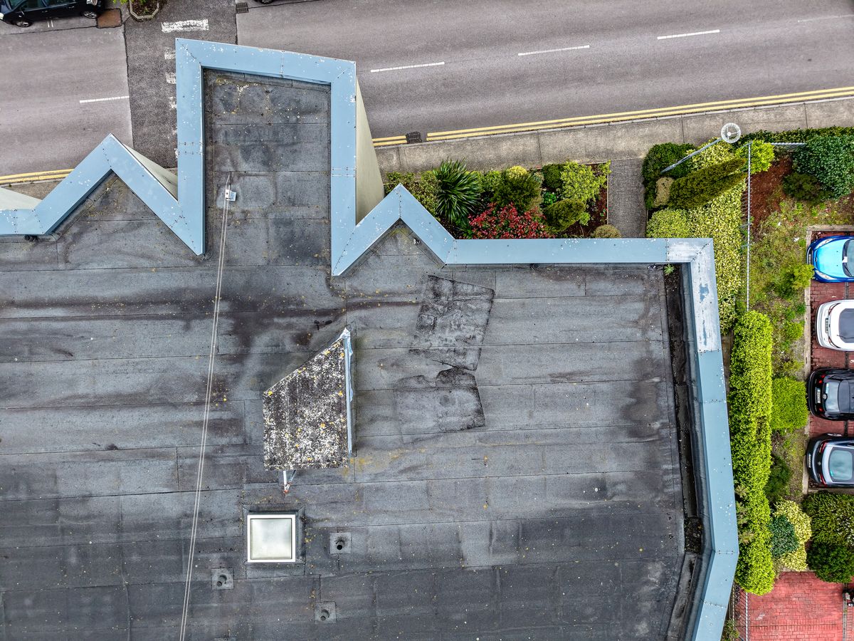 Aerial top-down view of a commercial flat roof with felt membrane and rooflights