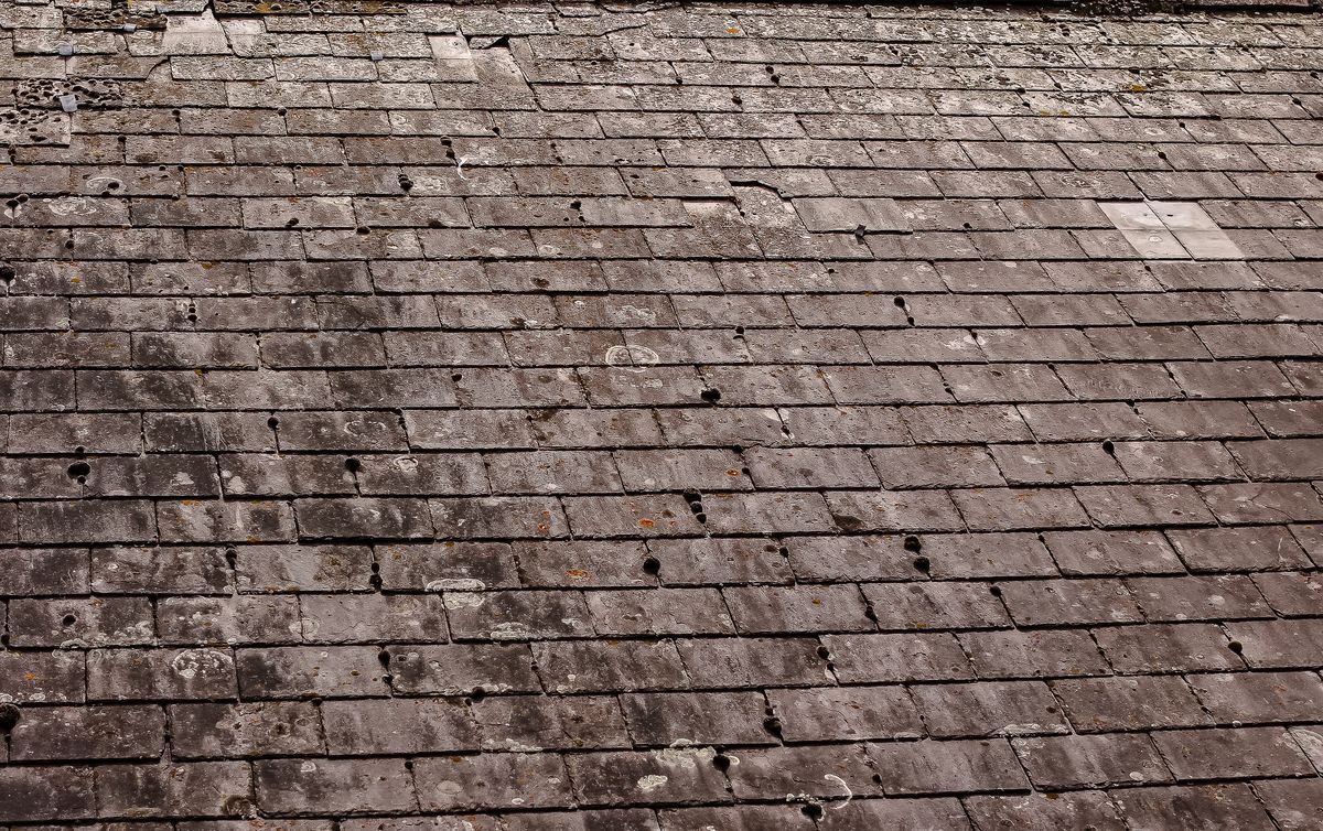 Aerial view across a pitched natural-slate roof during a condition survey
